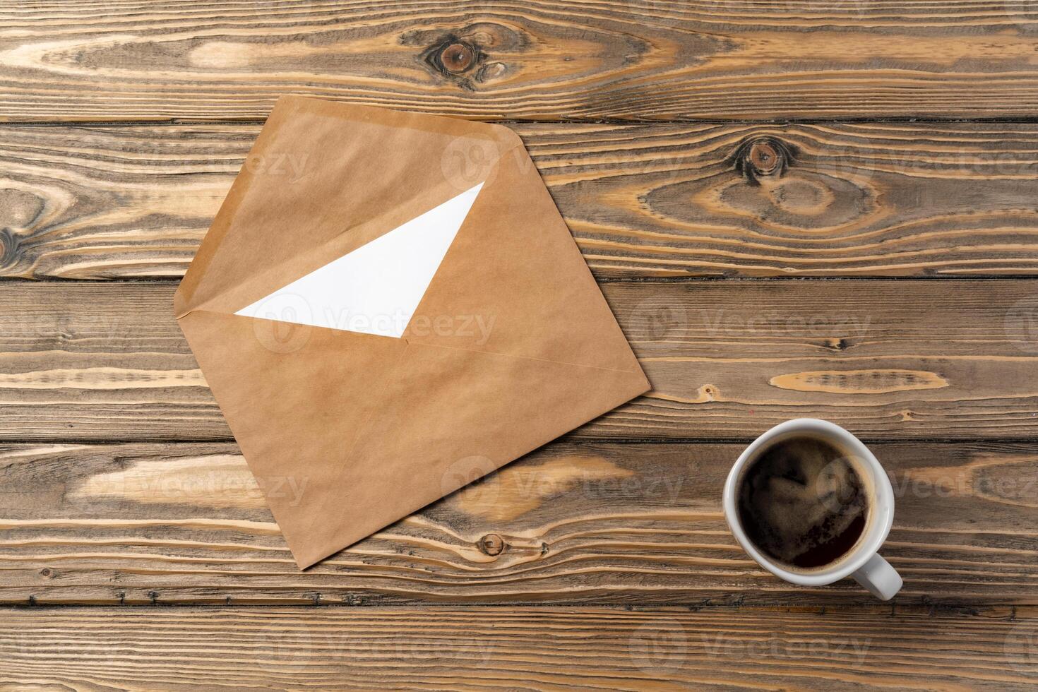 Vintage envelope with empty card, pen on wooden table top view photo