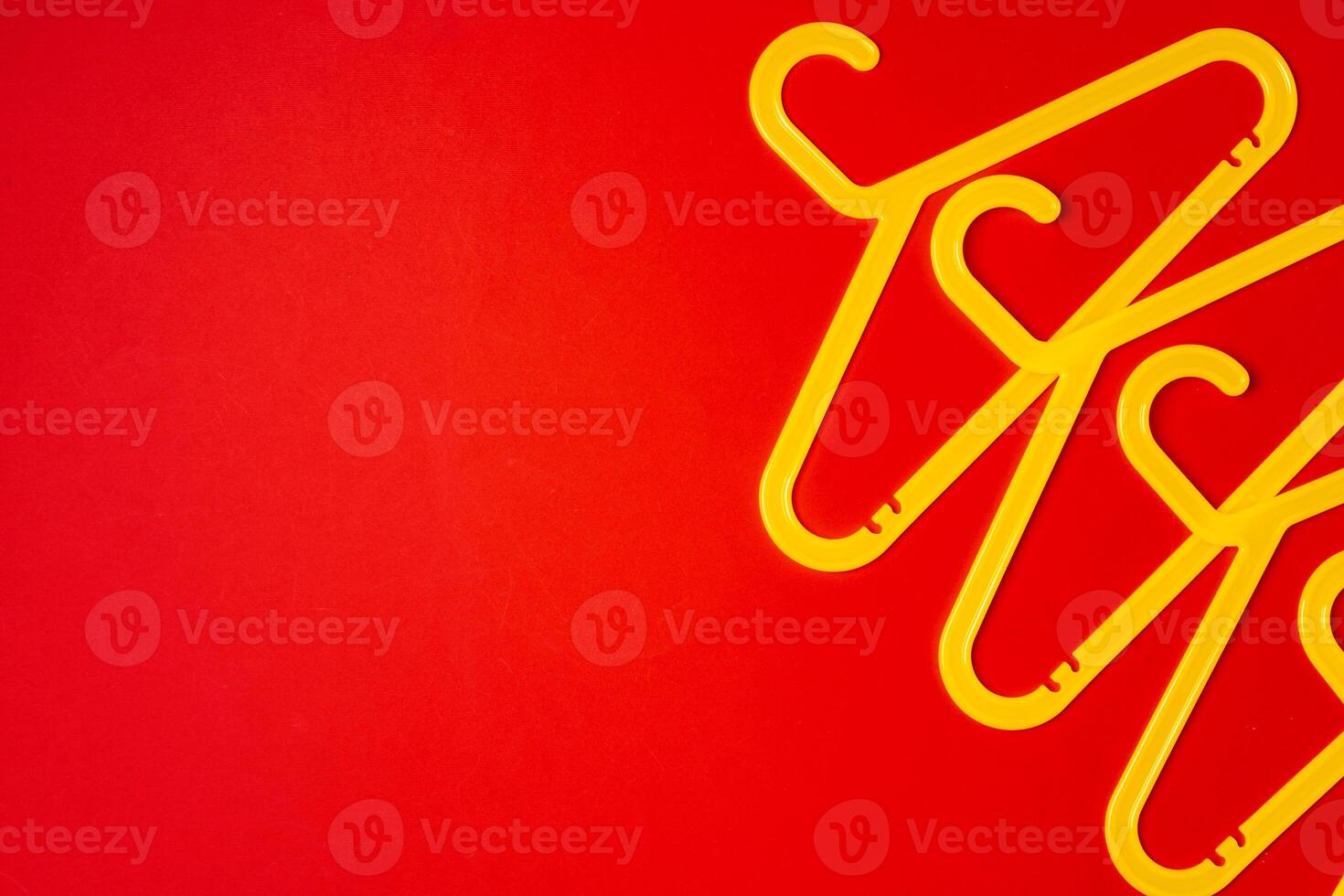 Hanger on red paper background. Minimalistic fashion concept. Top view photo