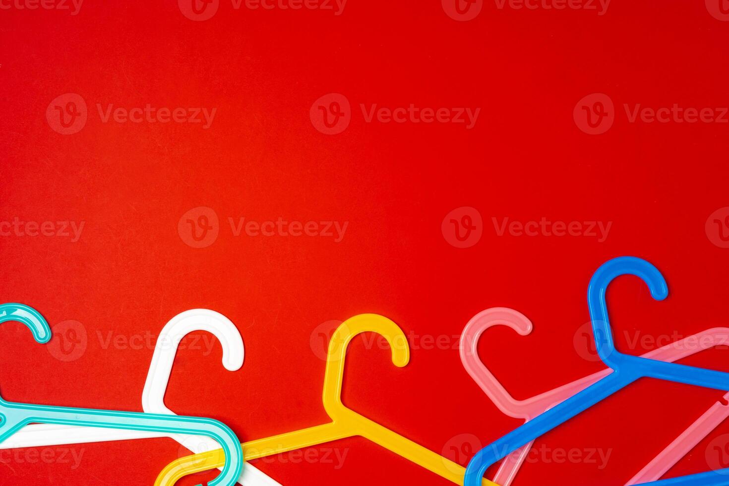 Hanger on red paper background. Minimalistic fashion concept. Top view photo