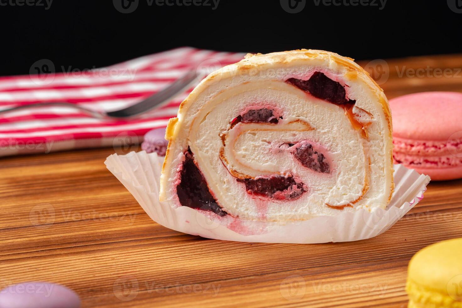 Meringue roll cake with cream on wooden table photo