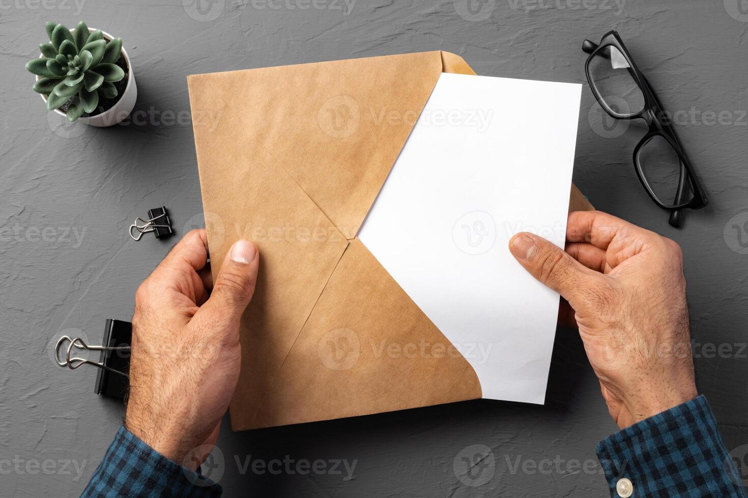 Business correspondence. Top view of man hands holding mockup envelope with letter. Copy space. photo