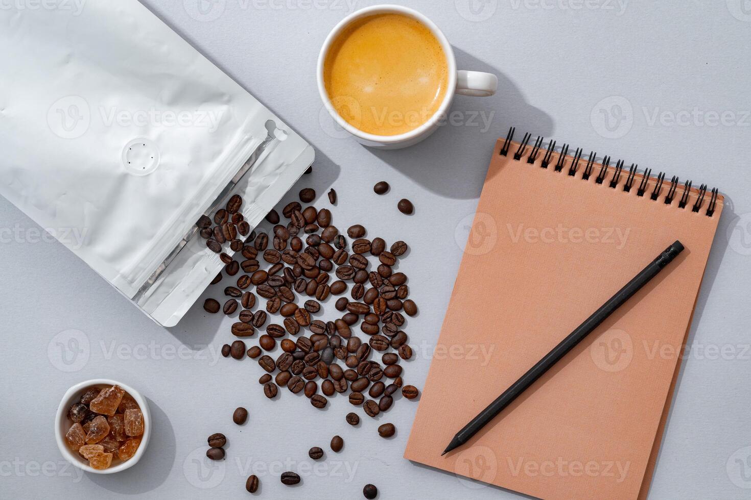 Cup of coffee with notebook on gray background top view photo