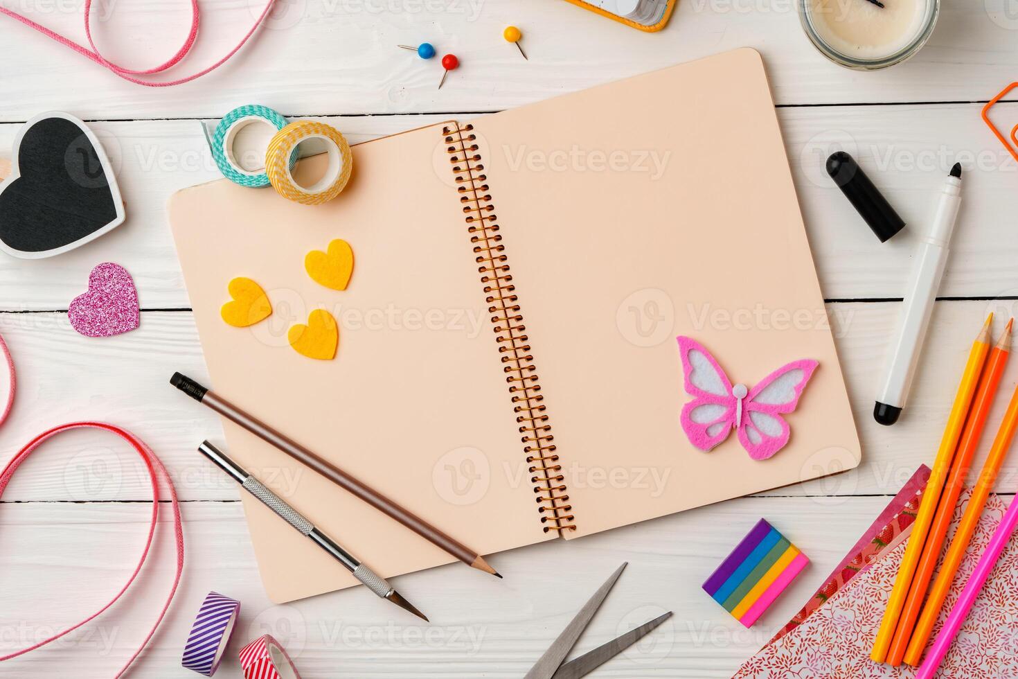 Creative workspace with colorful stationery and decorations on a white wooden desk photo