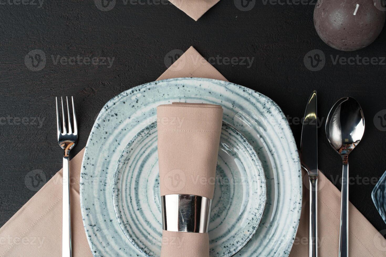 Table setting. Plates with abstract pattern on black table photo