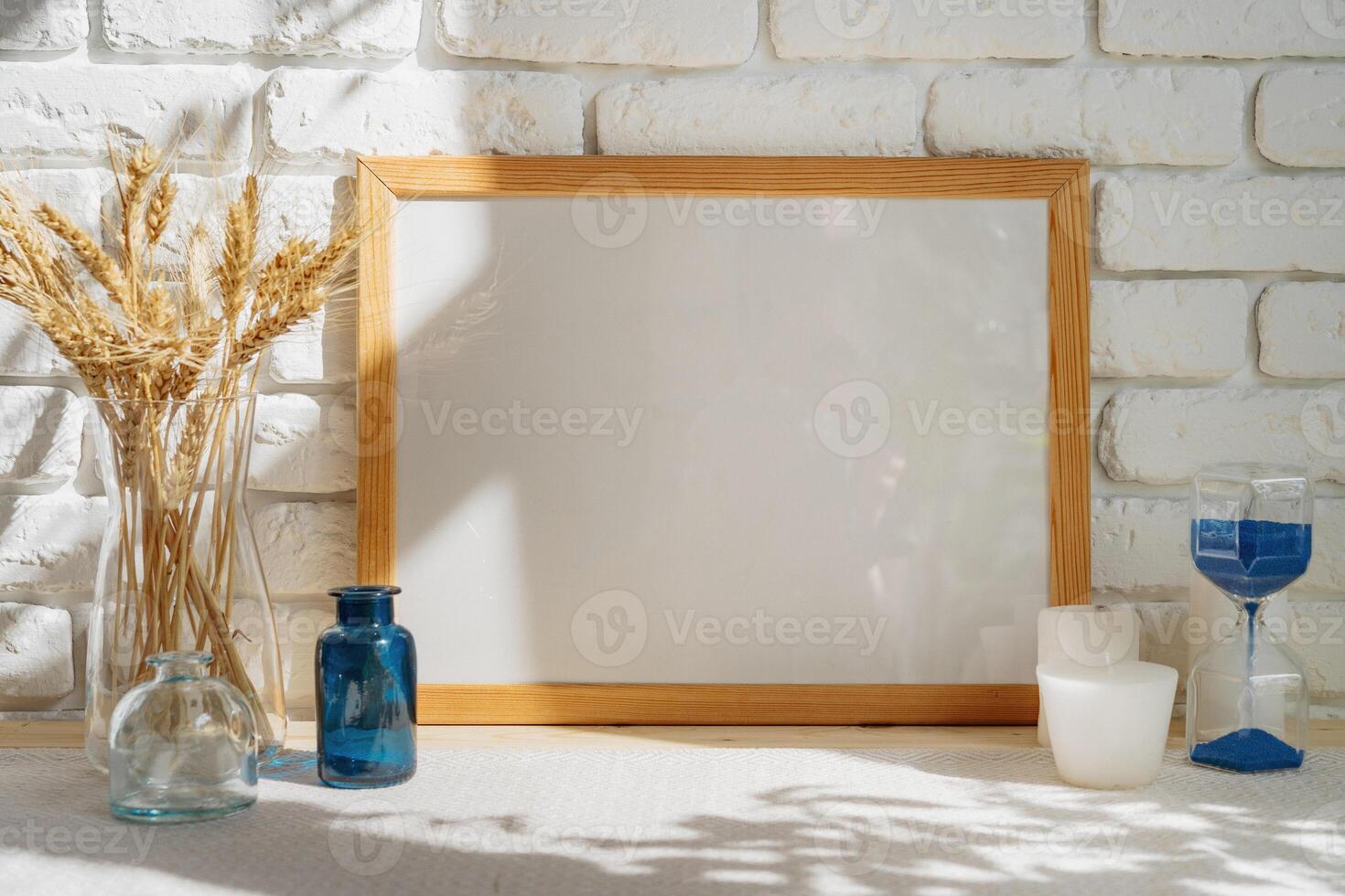 Mockup with a frame and dry flowers in a vase on a white table photo