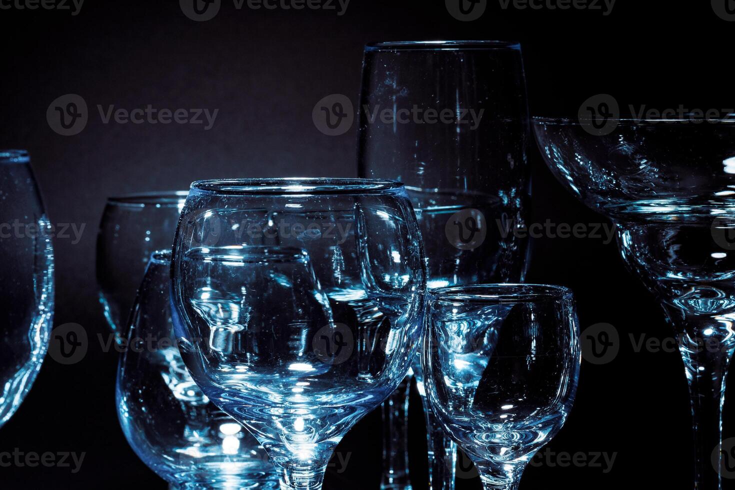 Empty glasses for drinks on dark background photo