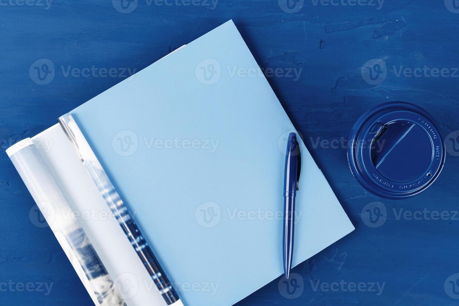 Top view of open magazine page with copy space on classic blue background photo