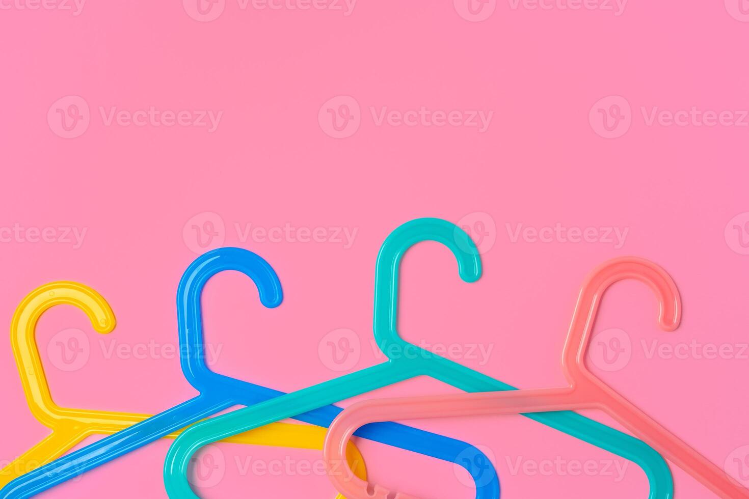 Flat lay composition with empty hangers on pink background photo