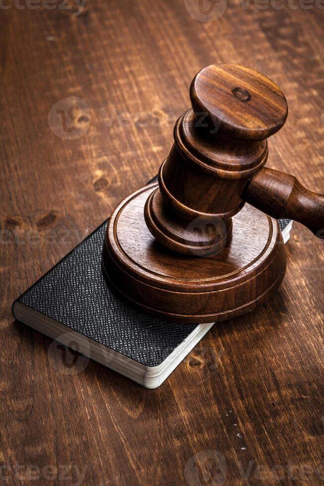 Image of wooden judge hammer on notepad photo