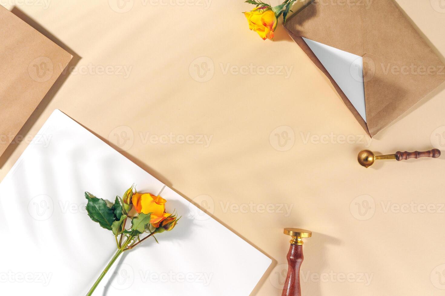 Craft paper envelope with yellow roses on beige background photo