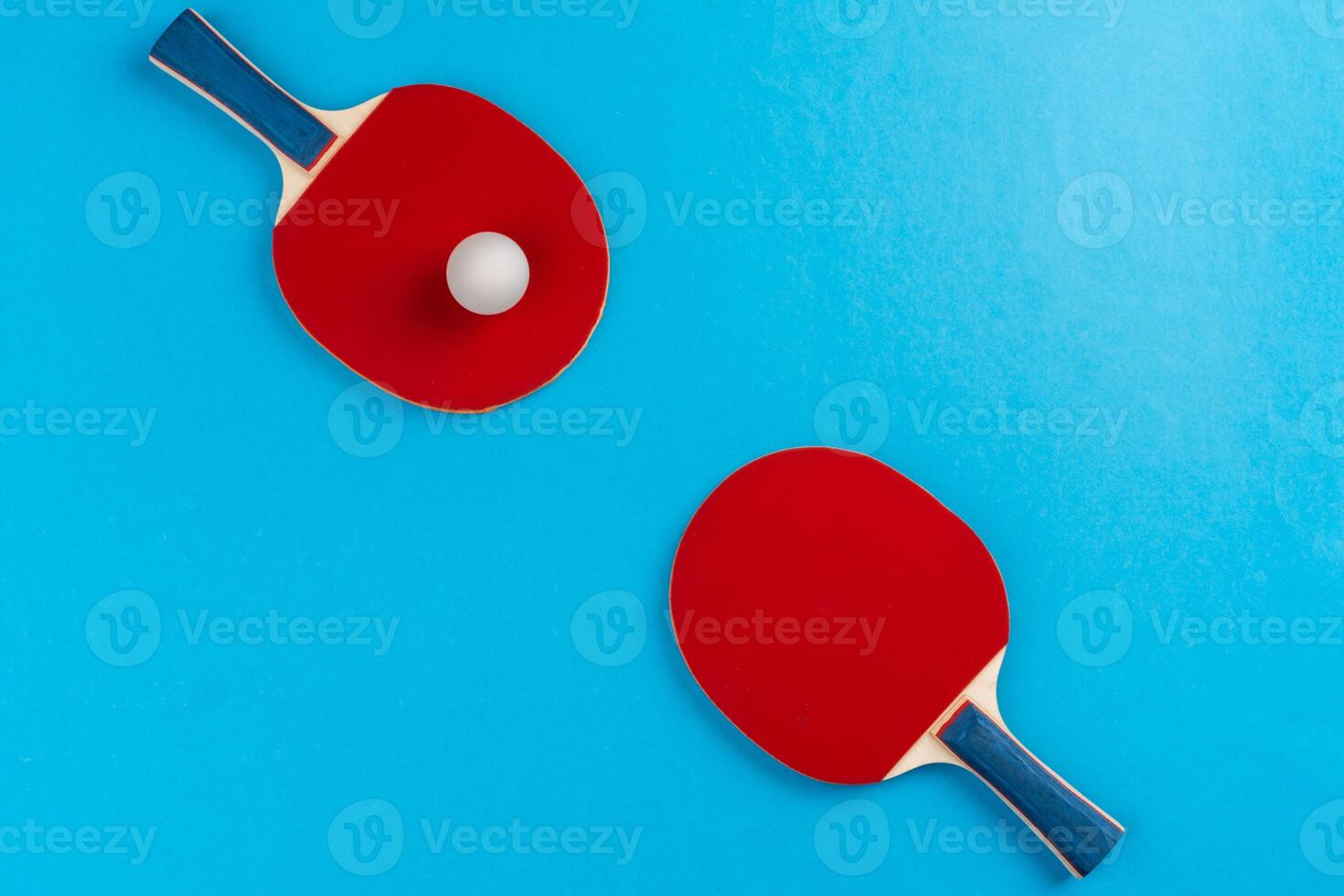 Ping pong racket and ball on blue background photo