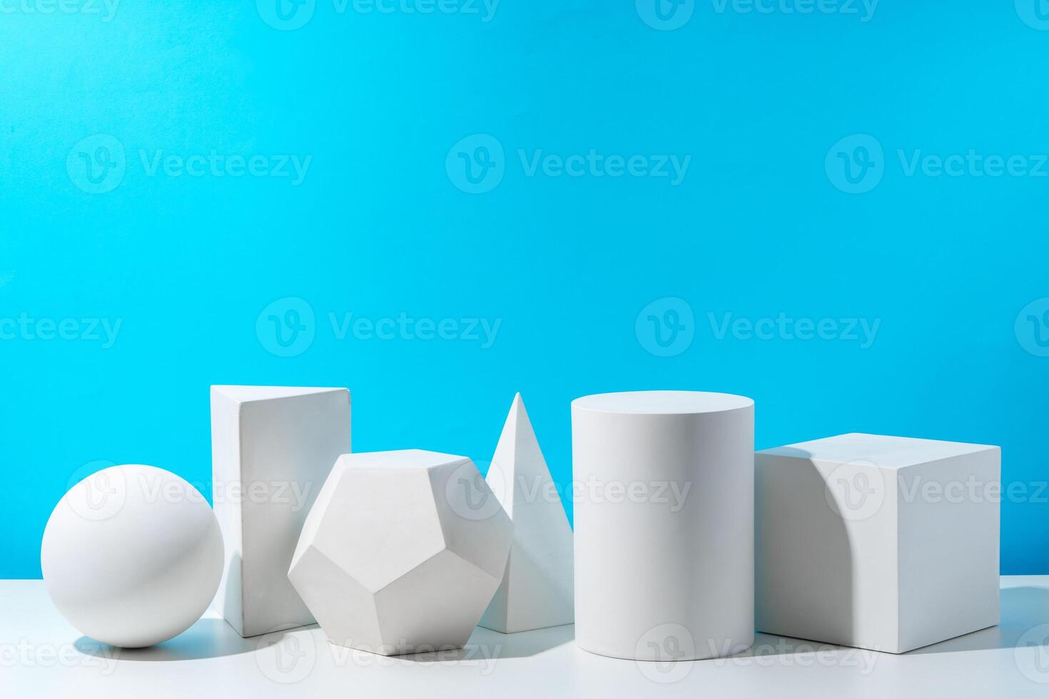 Various geometric shapes arranged on a surface against a bright blue background photo