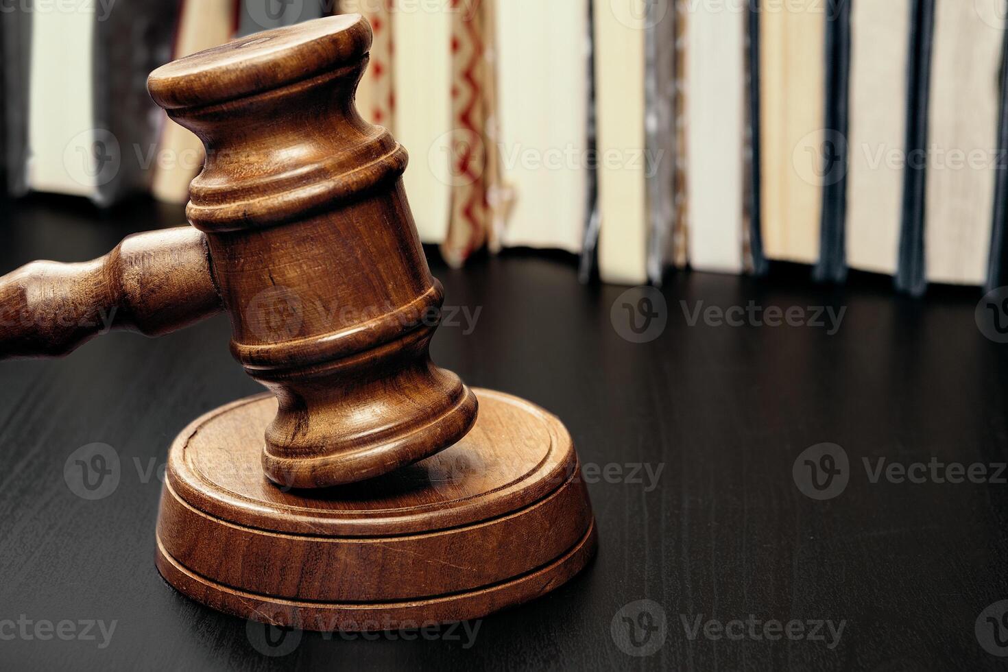Judge's gavel on wooden table in dark photo