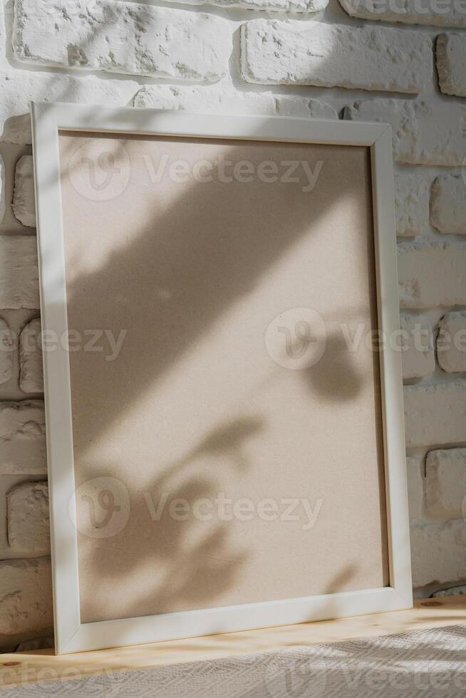 Photo frames on floor over white brick wall