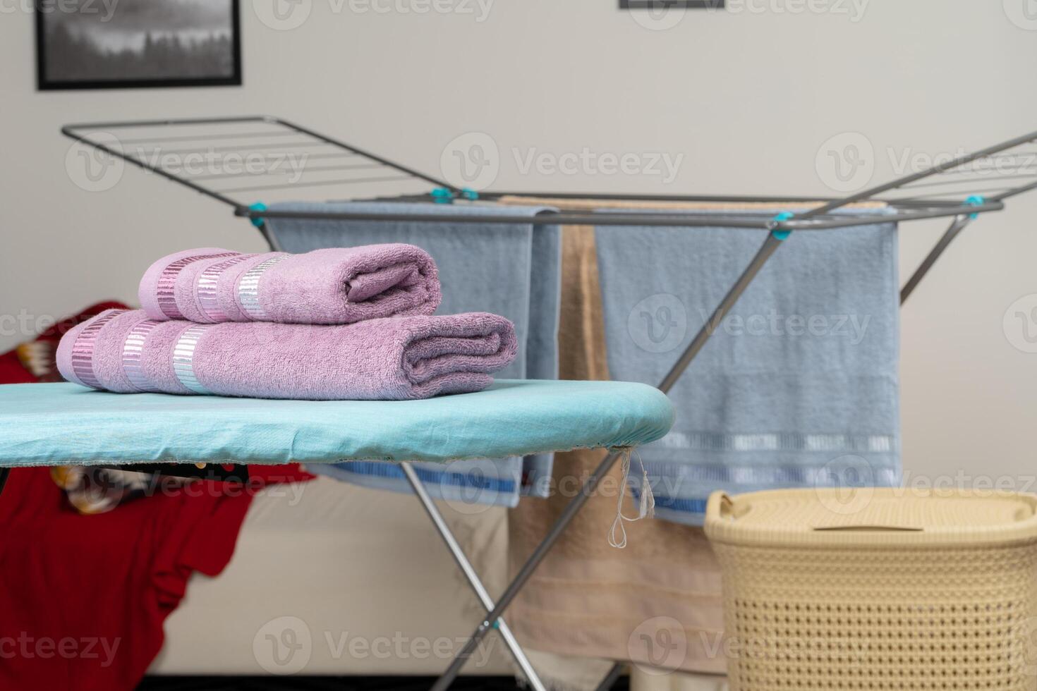 Housework concept. Ironing towels on ironing board photo