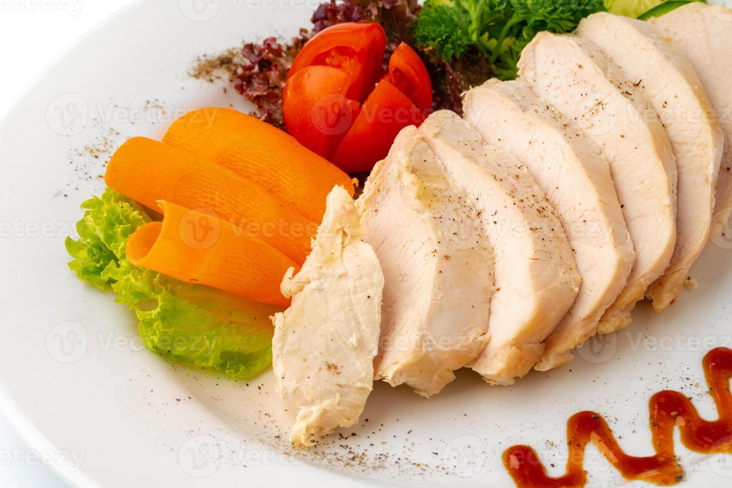 Pieces of boiled chicken breast with vegetables over white background photo