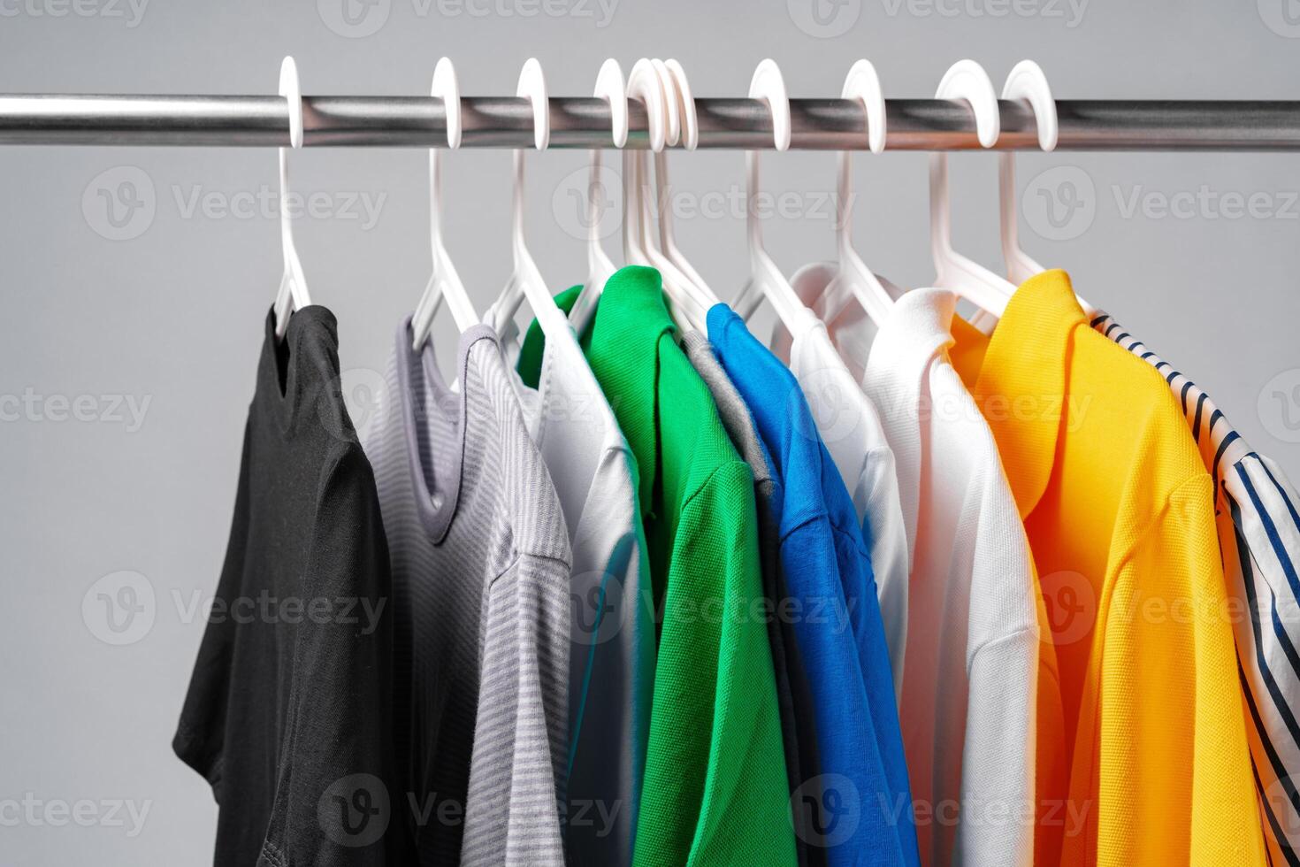 Clothes hang on clothing rack over white background. photo