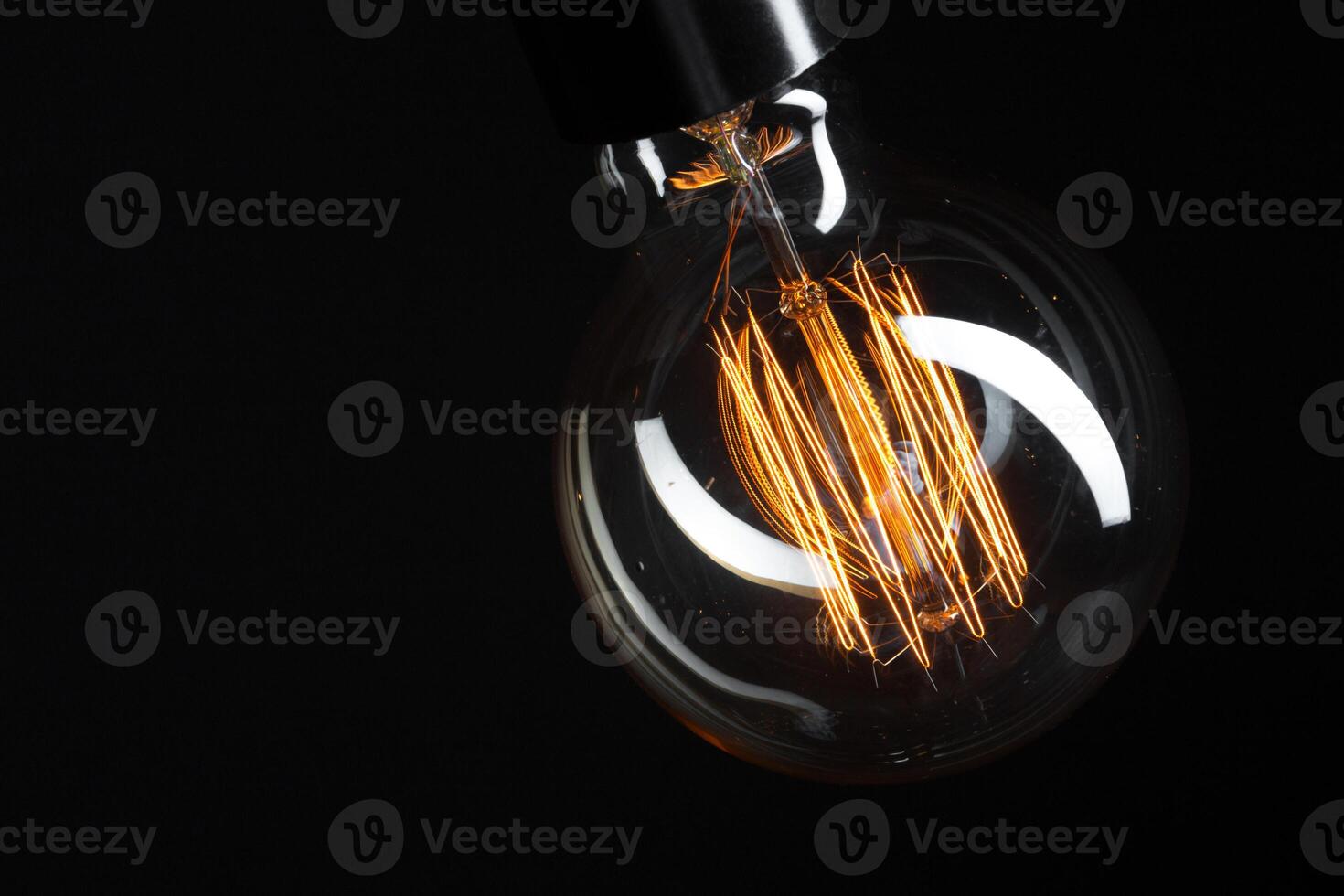 A classic Edison light bulb on dark background with space for text photo