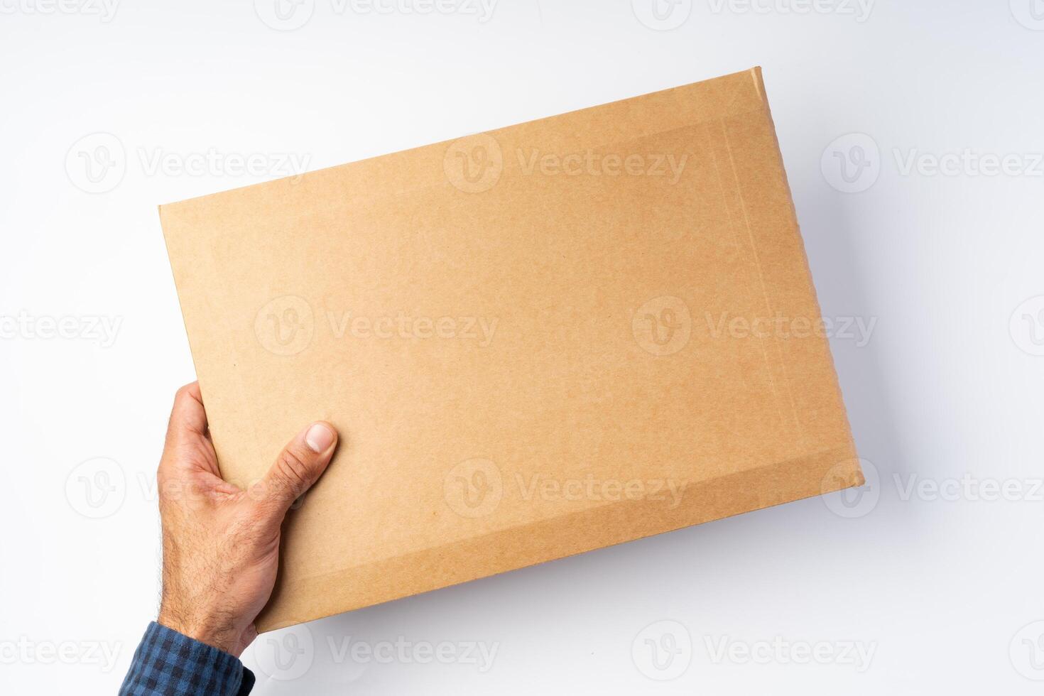 Male hand holding parcel post against white background photo