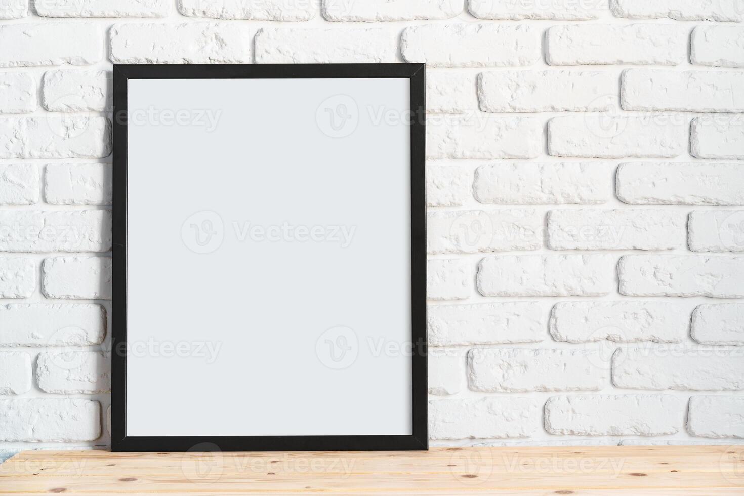 Photo frames on floor over white brick wall