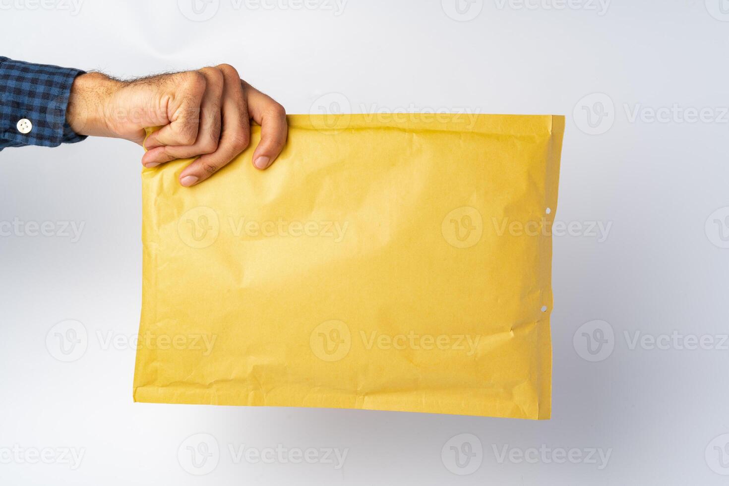 Male hand holding parcel post against white background photo