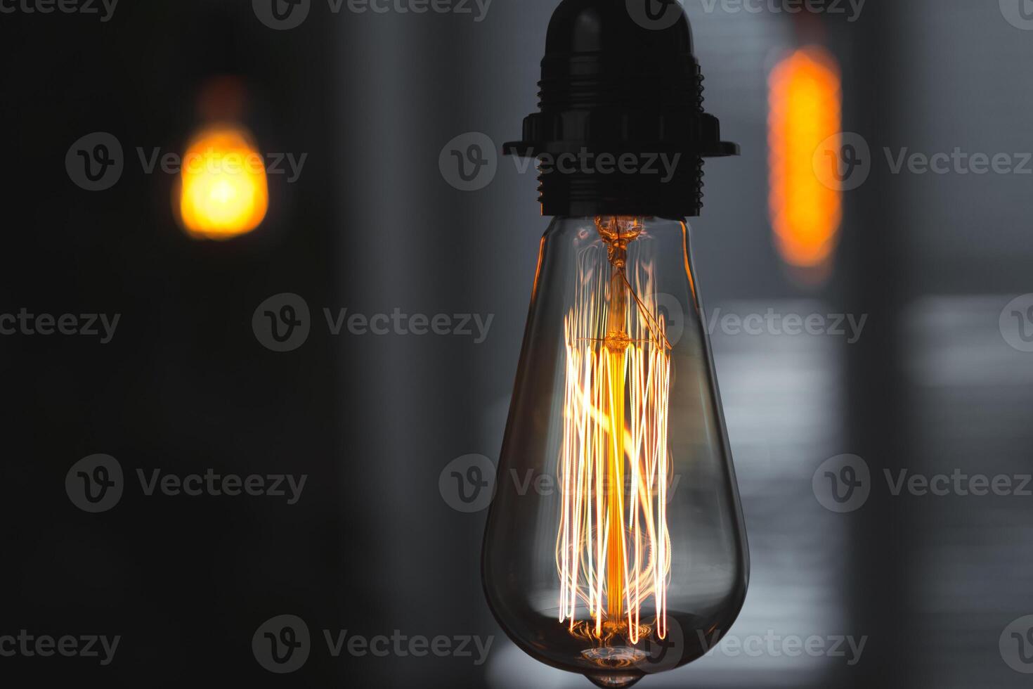A classic Edison light bulb on dark background with space for text photo