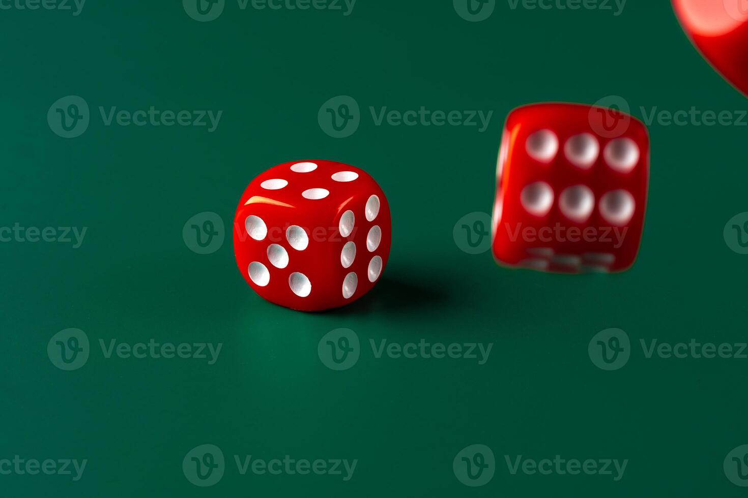 Red dice on green background close up photo