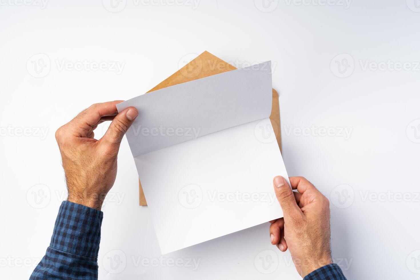 Top view of male hands hold , open an envelope above white background photo