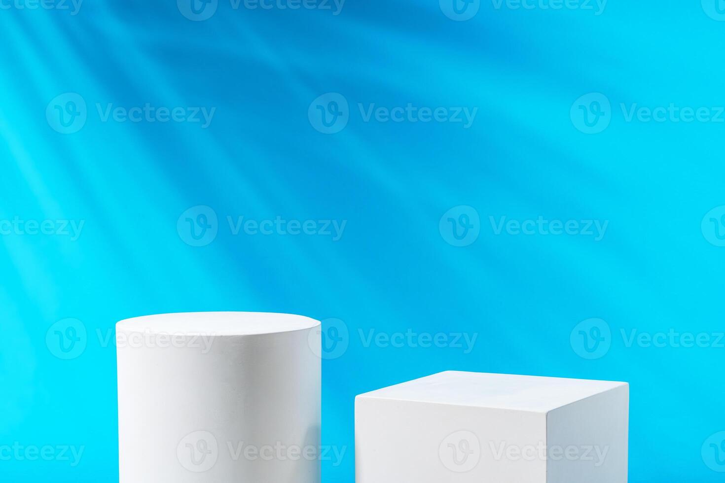 Two geometric shapes on display against a bright blue background in a modern setting photo