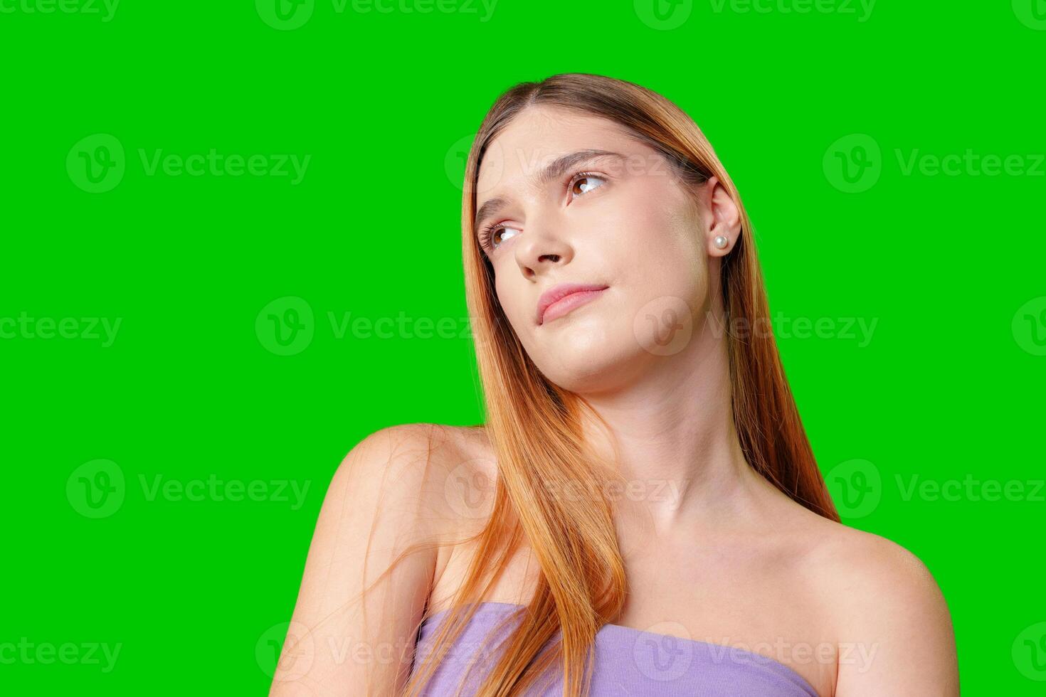 Woman Wearing Black Jeans and a Purple Top Posing in Front of a Green Screen photo