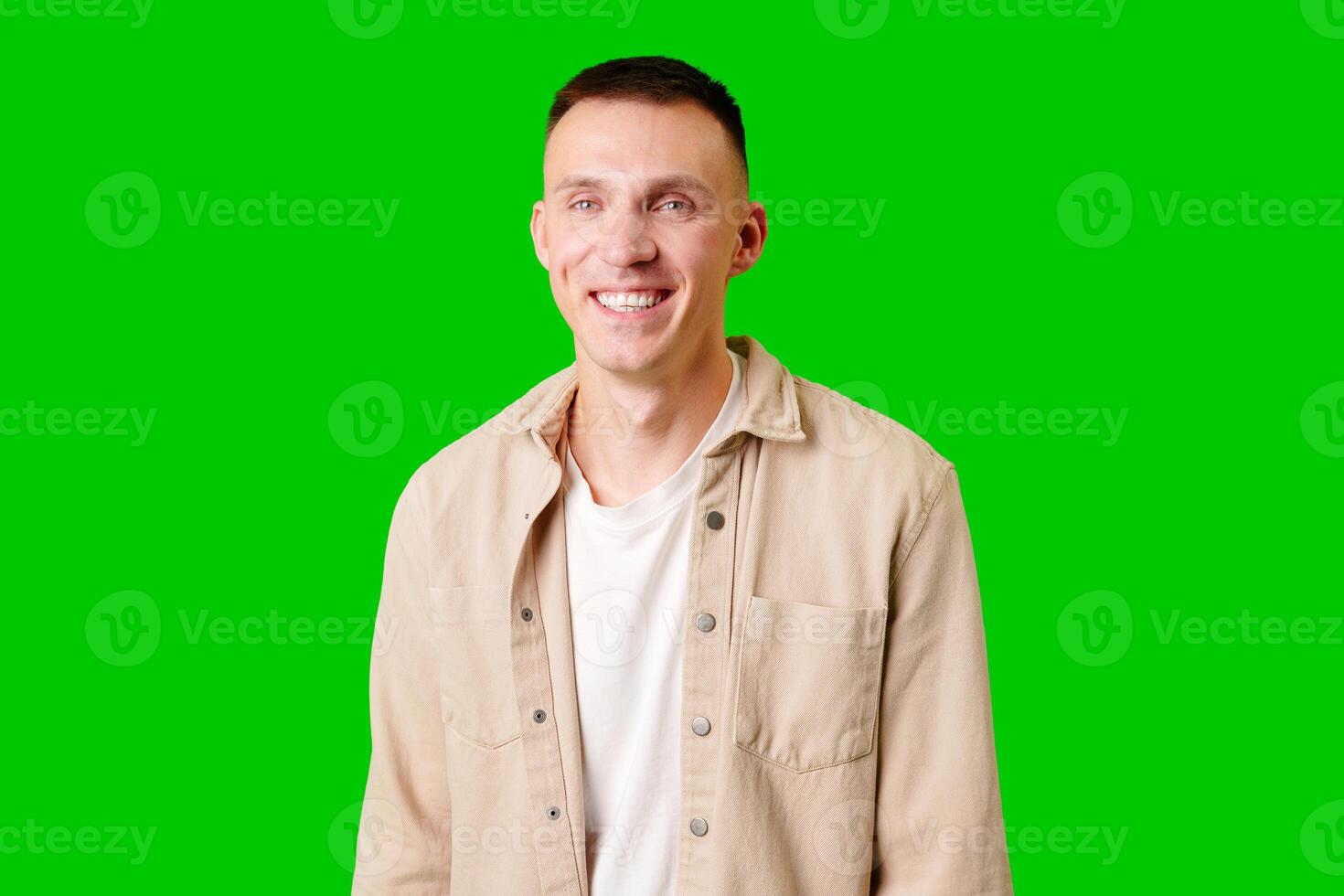 Young Man With Short Hair Smiling Against a Bright Green Background photo