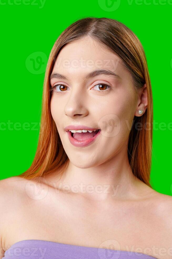 Young Woman With Surprised Expression in Front of Green Screen photo