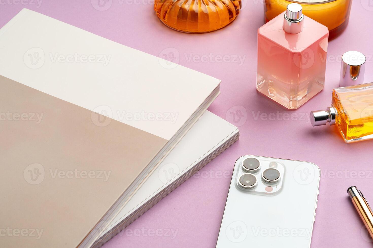 Colorful accessories and a smartphone arranged stylishly on a pastel pink surface photo