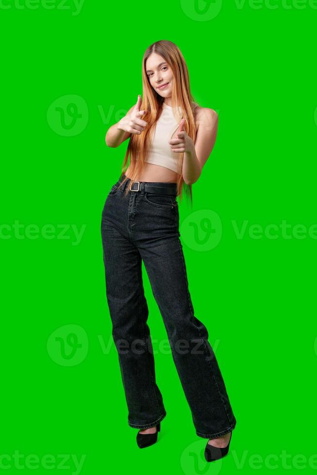 Smiling Young Woman Pointing at Camera With Green Screen Background photo