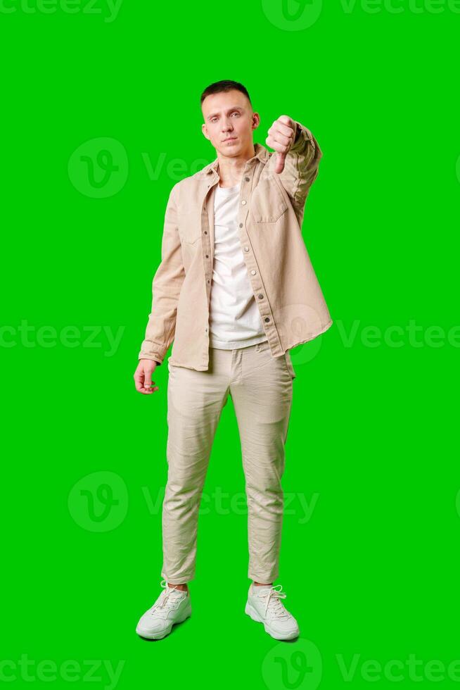 Young Man Making Disapproving Gesture Against Bright Green Background photo