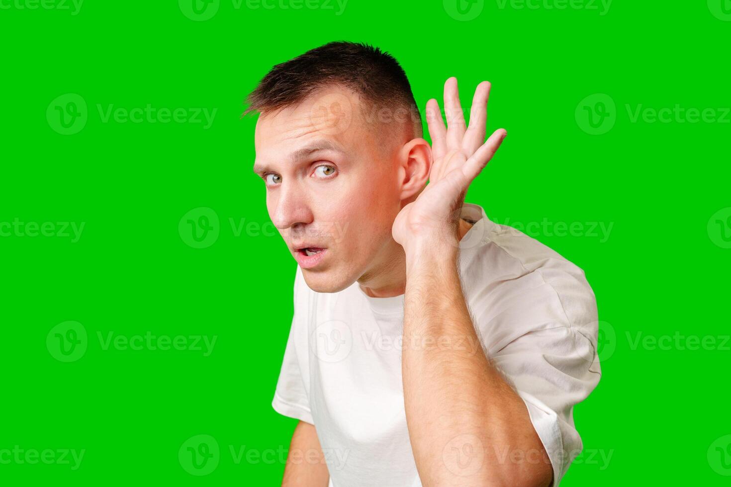 Curious Man Listening Intently Against Bright Green Background photo