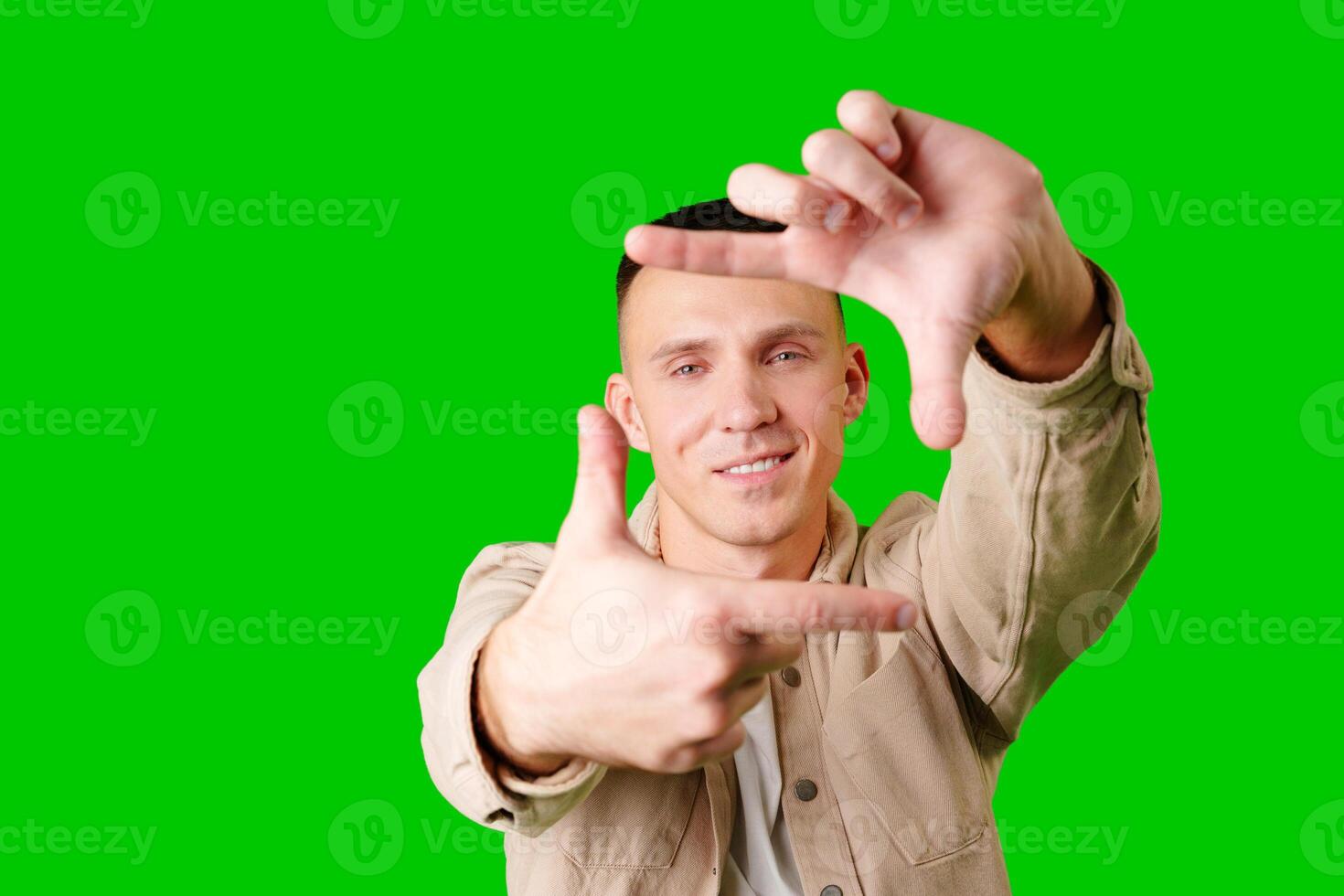 Young Man Posing With Hand Gesture Against Bright Green Background photo