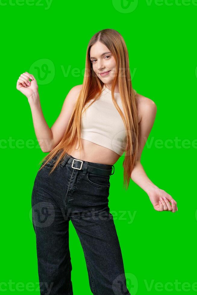 Young Woman In White Tank Top Posing Against A Green Screen photo