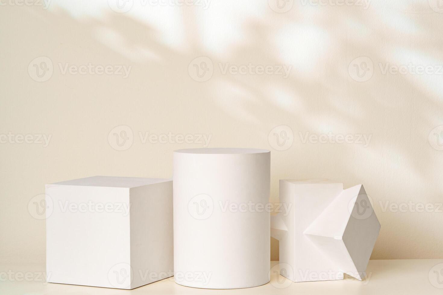 Three geometric shapes in soft white tones on a light background with gentle shadows photo