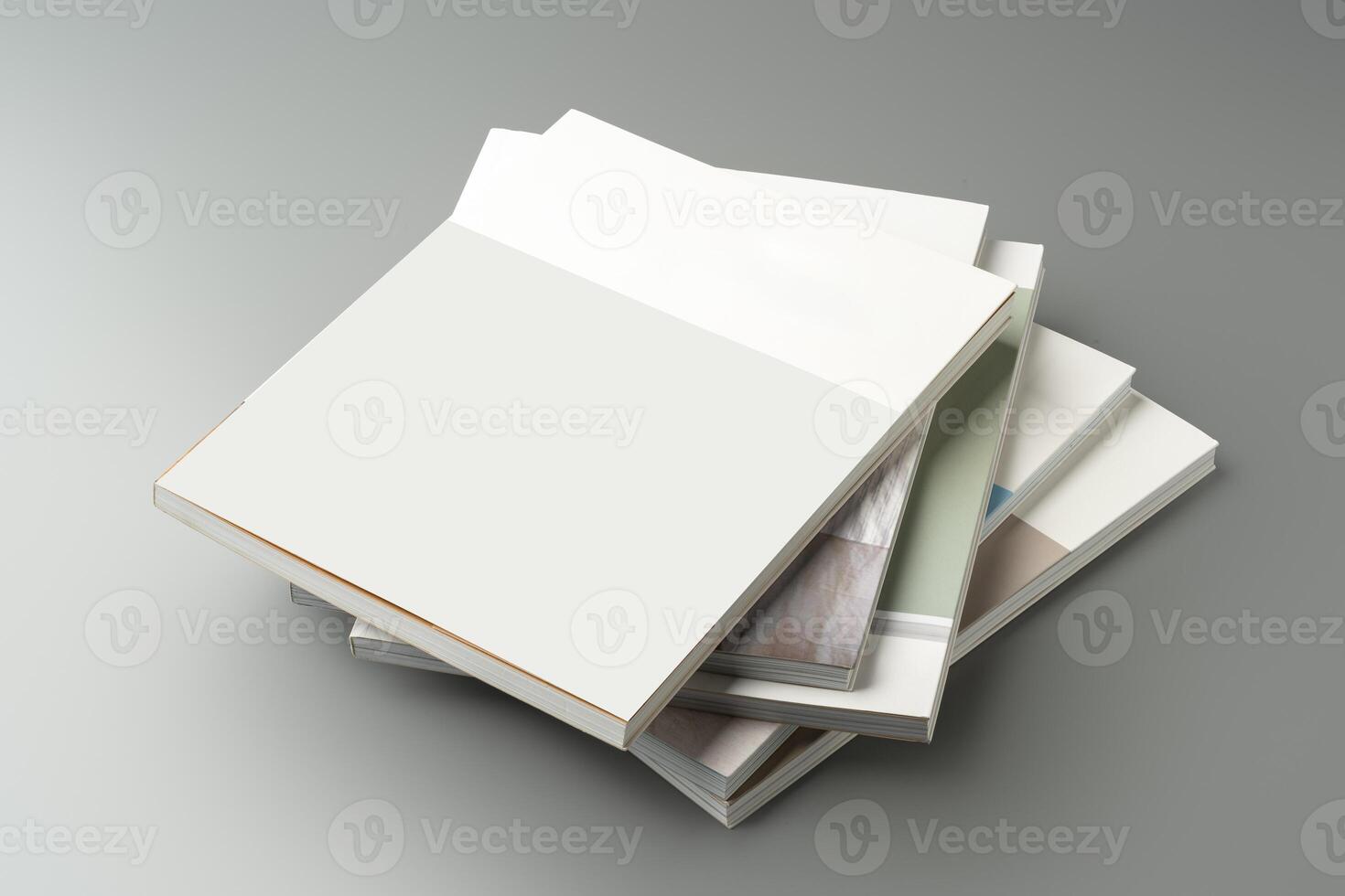 A stack of blank notebooks arranged neatly on a simple grey background photo