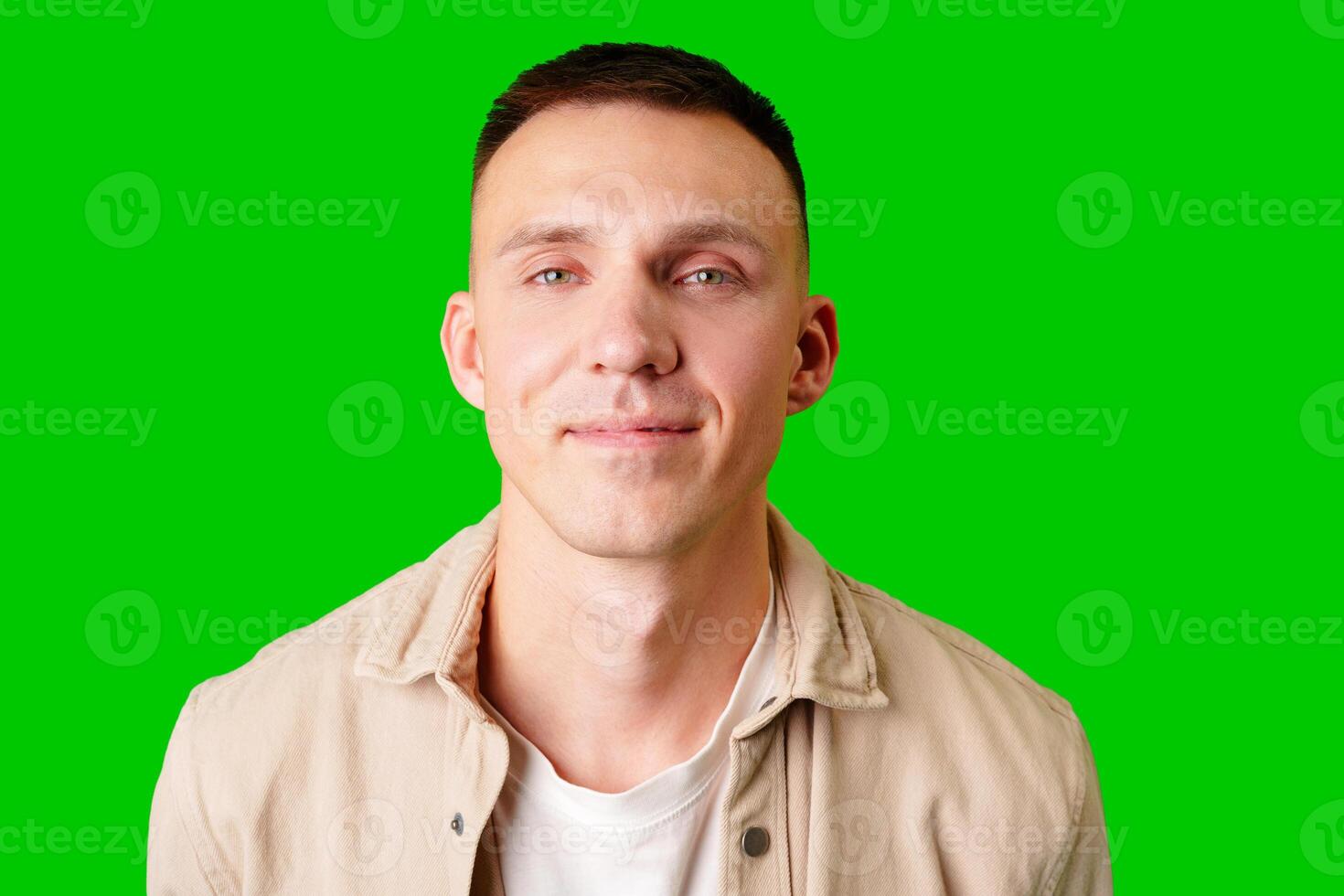 Young Man With Short Hair Smiling Against a Bright Green Background photo
