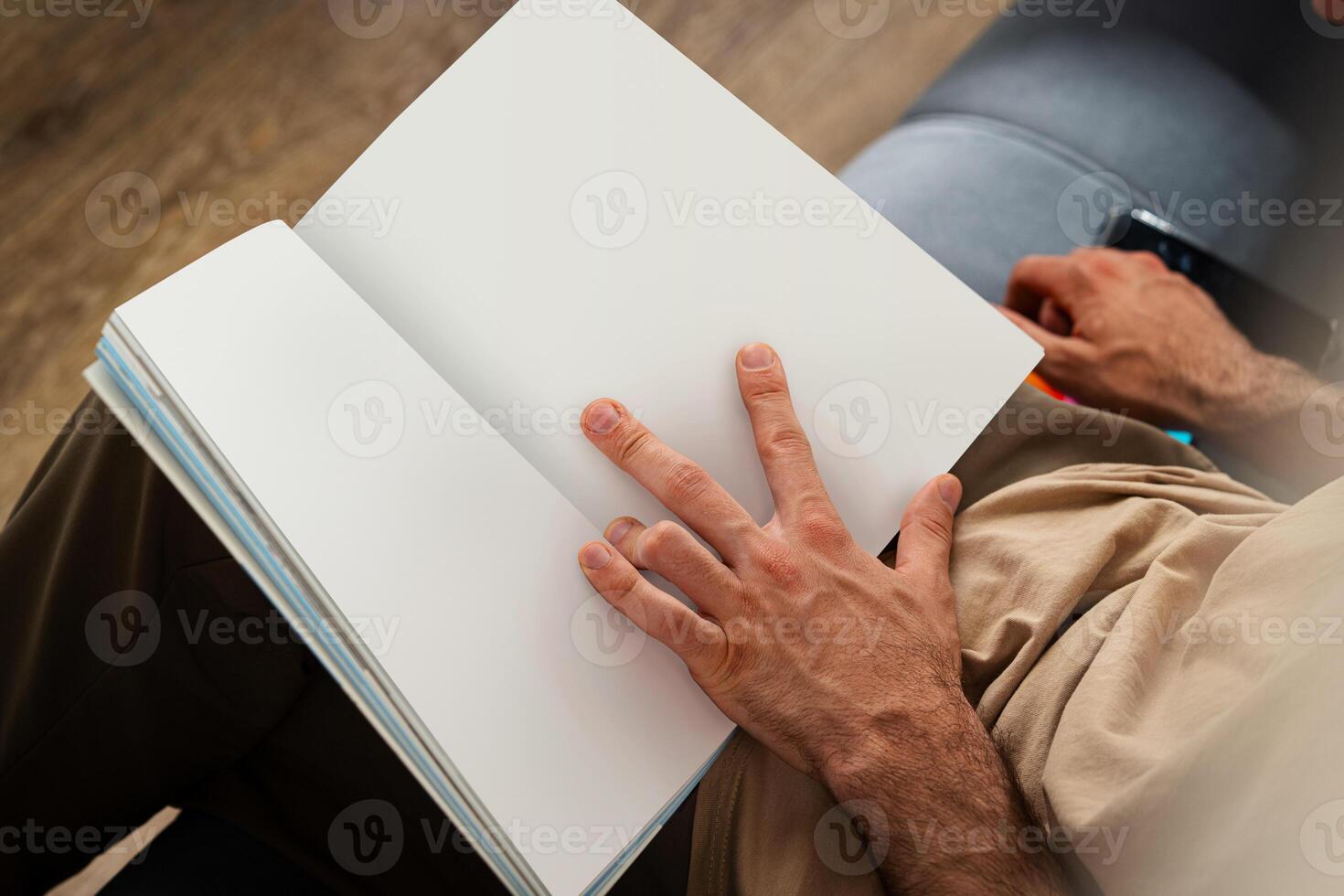 Close Up of Person's Hands Holding Open Book While Sitting photo