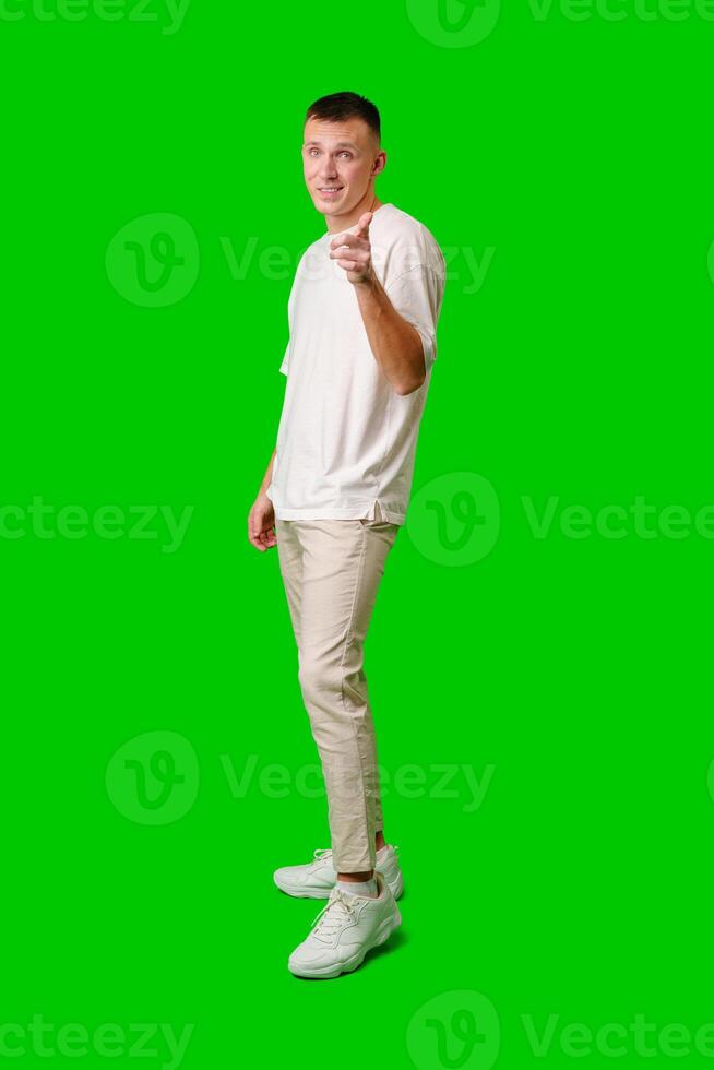 Young Man Posing Playfully in Casual Attire With Green Background photo
