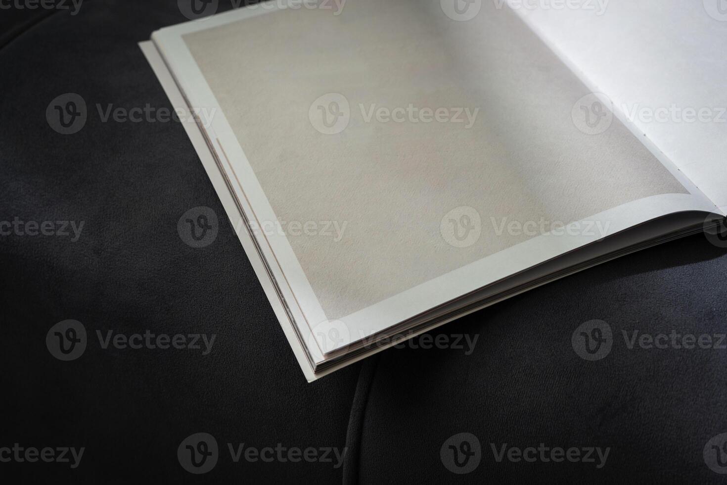 Stack of Magazines on a Black Leather Couch in Soft Light photo