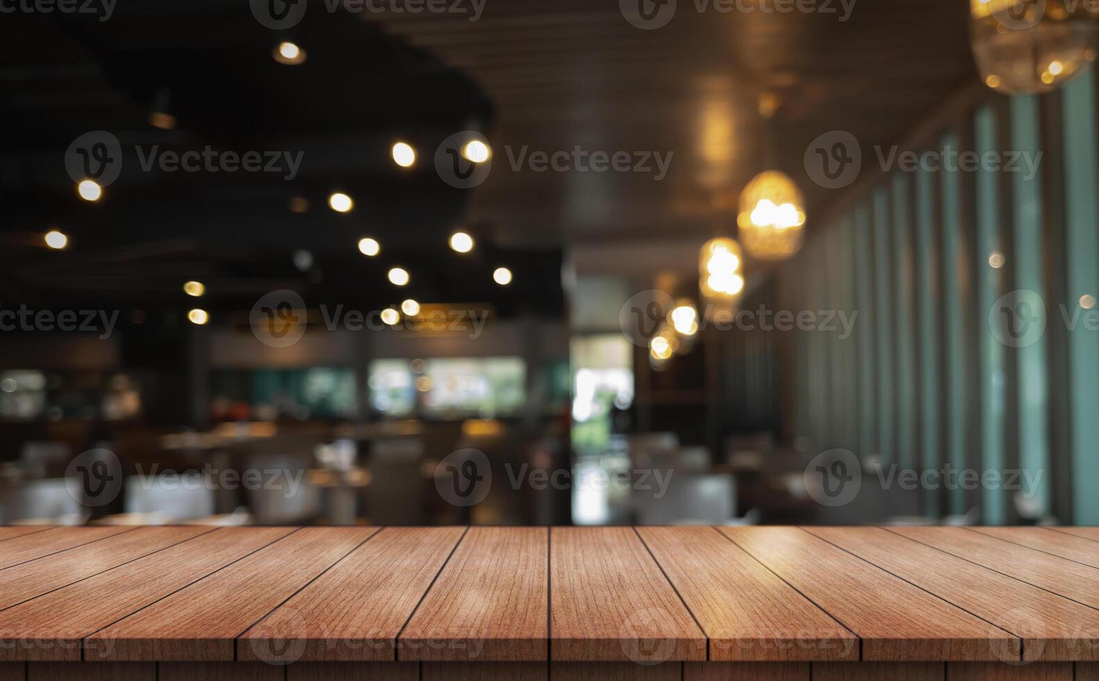 Empty wooden table top with lights bokeh on blur restaurant background. photo