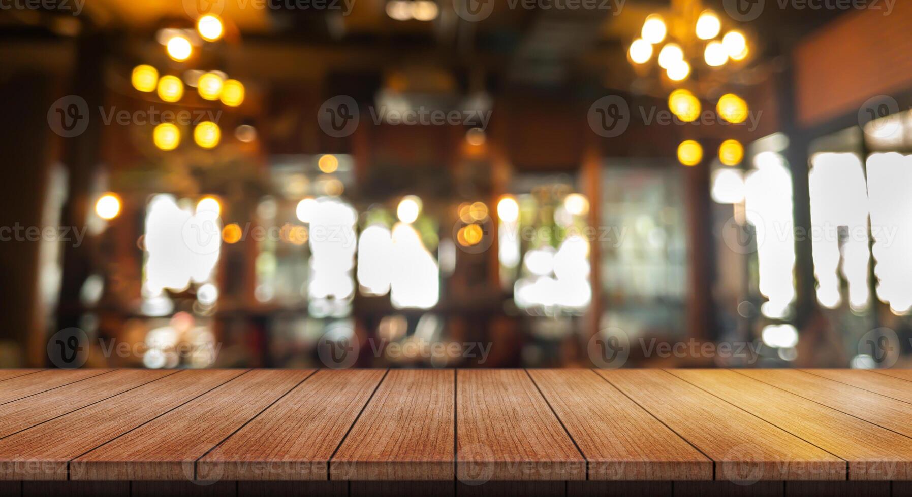 Empty wooden table top with lights bokeh on blur restaurant background. photo