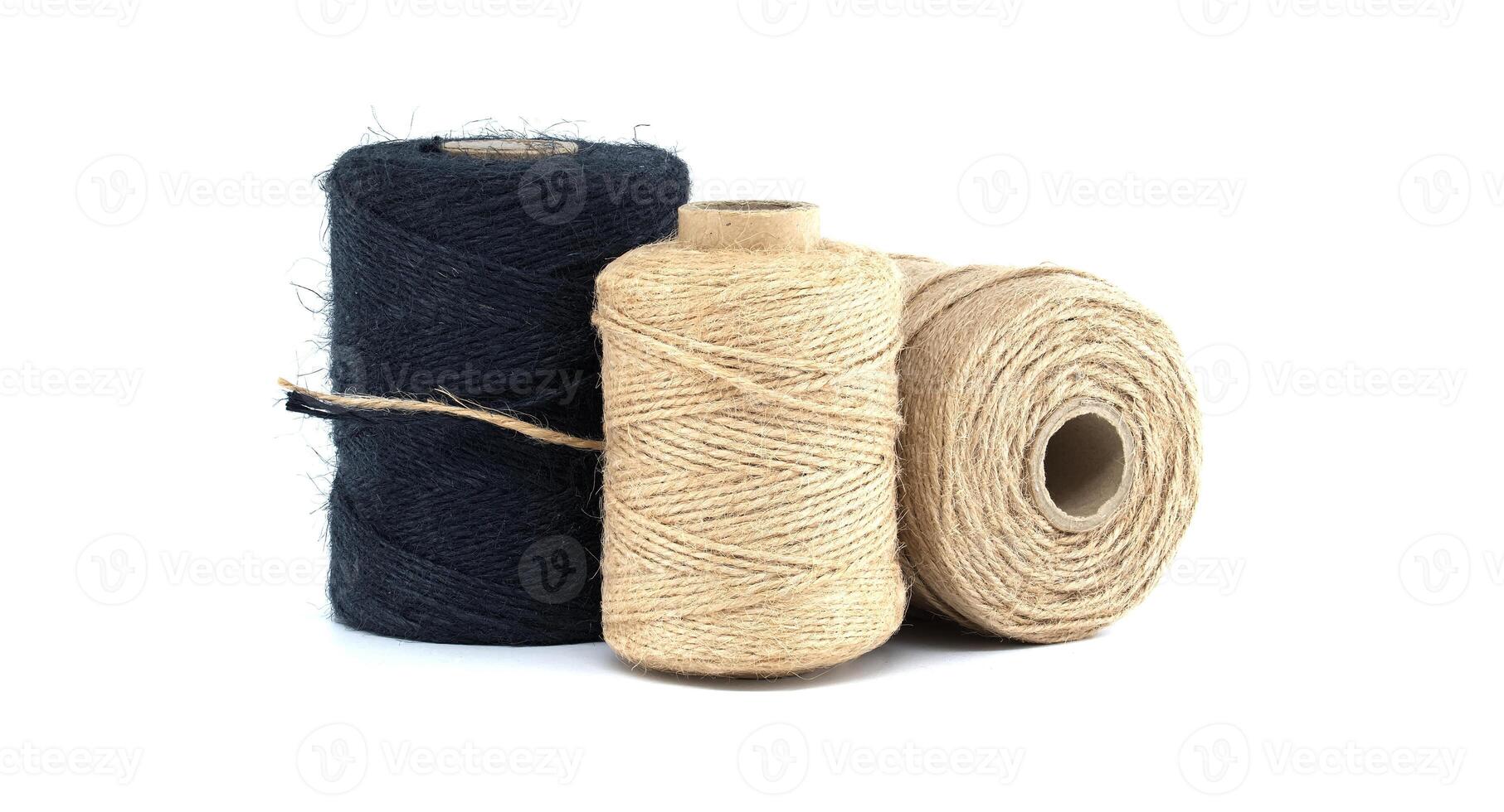 Assorted jute and twine spools on white background showcasing natural fiber materials photo