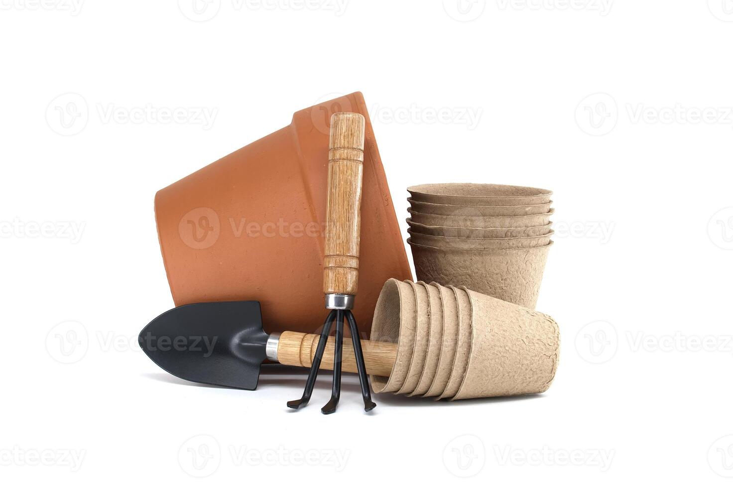 Gardening tools with terracotta pot, biodegradable pots, and spool of twine on a white background photo