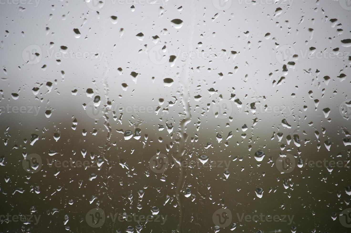 The raindrops on the window are small and numerous photo