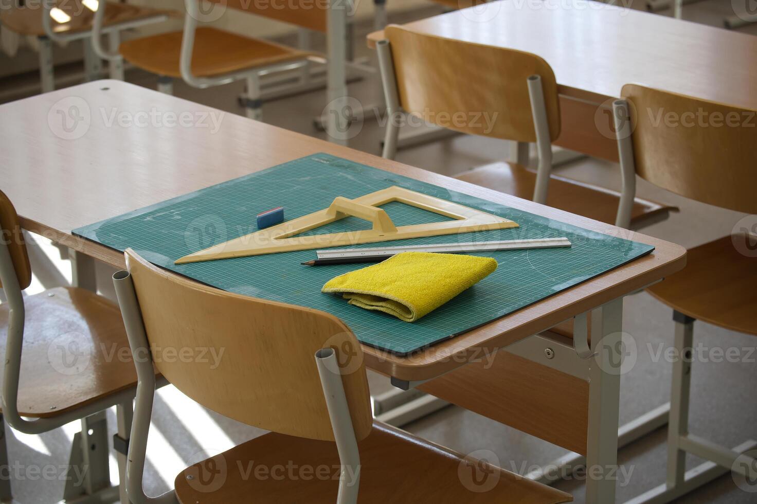 Classroom desk with math tools, ruler, and eraser on a cutting mat photo
